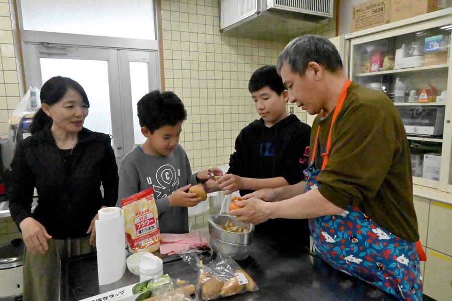 一緒に下ごしらえする妻のバヤサーさん、三男のナスカさん、次男のエンカさん、バスカさん＝左から順