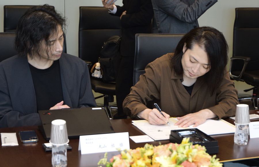 資本業務提携の成約証明書に署名するパンクチュアルの守時健社長（右）＝東京都中央区のＭ＆Ａキャピタルパートナーズ