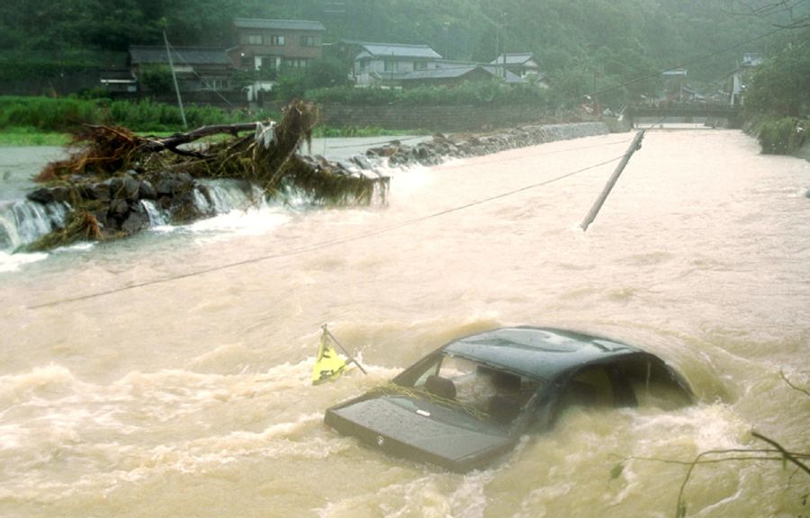 断続的に降り続いた雨で水かさが増し、車ものみ込んだ周防形川。隣接する田畑からもとめどなく濁流が流れ込む（２００１年９月７日午前８時ごろ、大月町周防形）