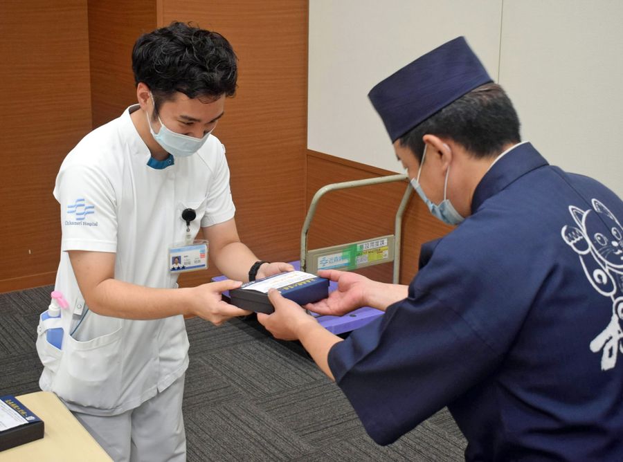 すしを受け取る医療スタッフ=左(高知市の近森病院)