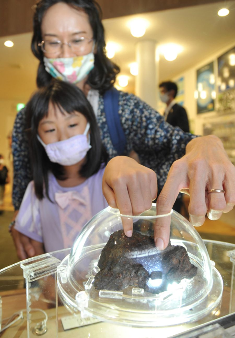 希少な隕石に触れる親子連れ（写真はいずれも高知市の高知みらい科学館）