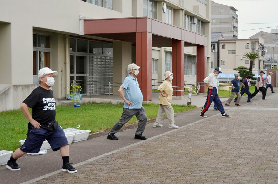 「若い人に世話はかけん」。早朝のラジオ体操で体を動かす高齢者ら(13日、高知市内)