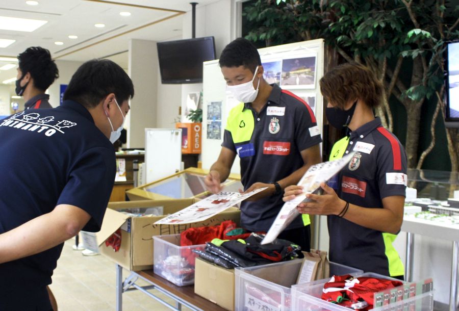 四万十市役所を訪れ、グッズを販売する高知ユナイテッドSCの岡田大介選手=右端=と井上聖也選手=右から2人目(同市役所)