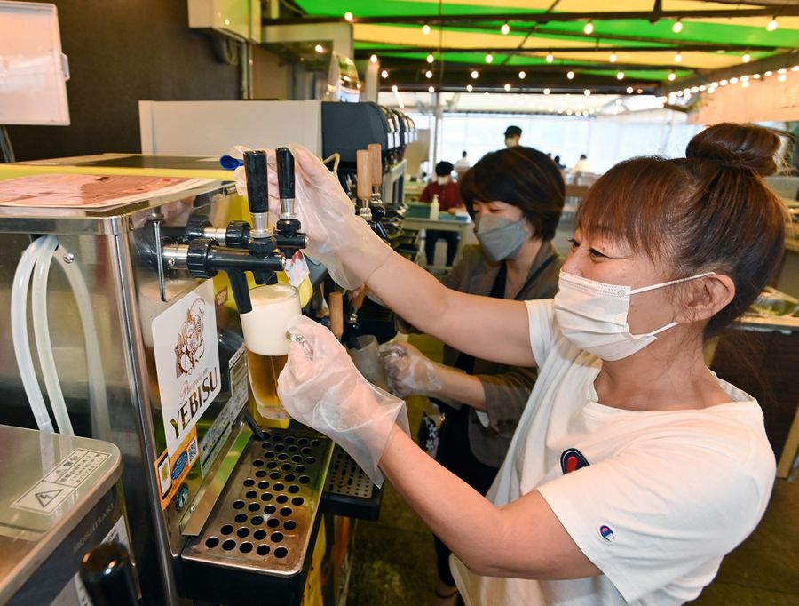 手袋とマスクを着用し、ビアガーデンの生ビールを楽しむ飲食客(高知市升形=森本敦士撮影)