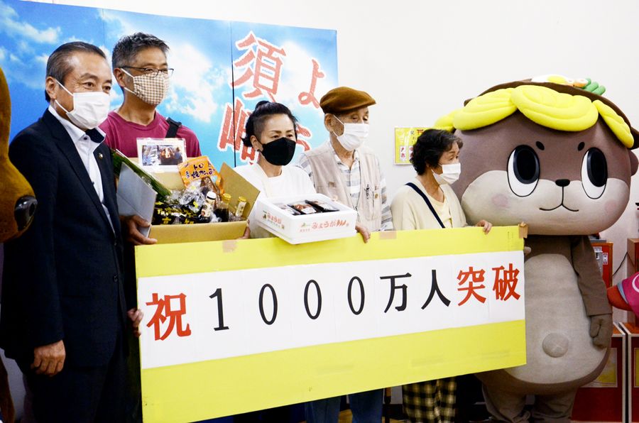 道の駅「かわうその里すさき」のレジ通過1千万人目になった杉本英史さん=左から2人目(須崎市の同駅)