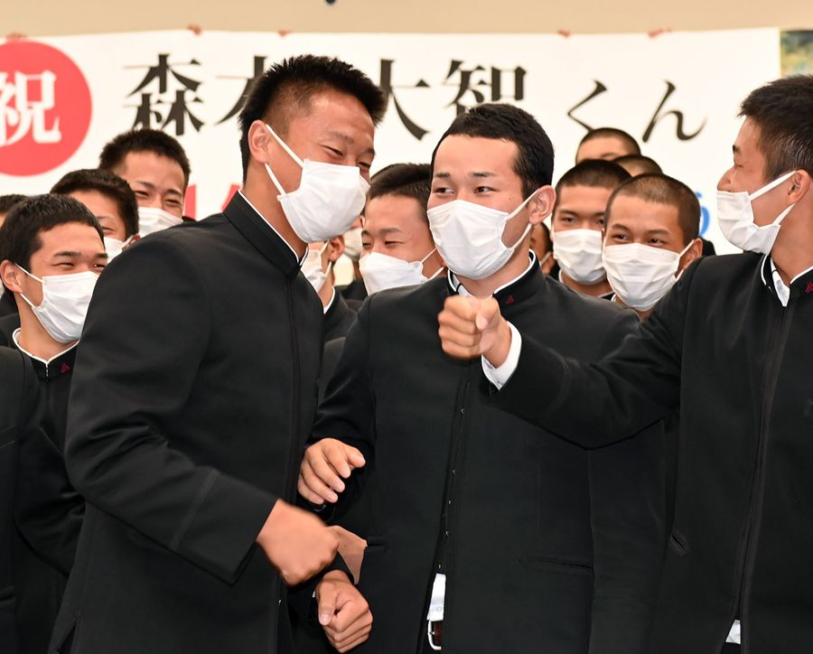 阪神に1位指名された高知高の森木大智投手=前列左。中高の6年間、バッテリーを組んだ吉岡七斗さん=同2人目=らの祝福を受け、笑顔を見せた(高知市旭天神町=森本敦士撮影)