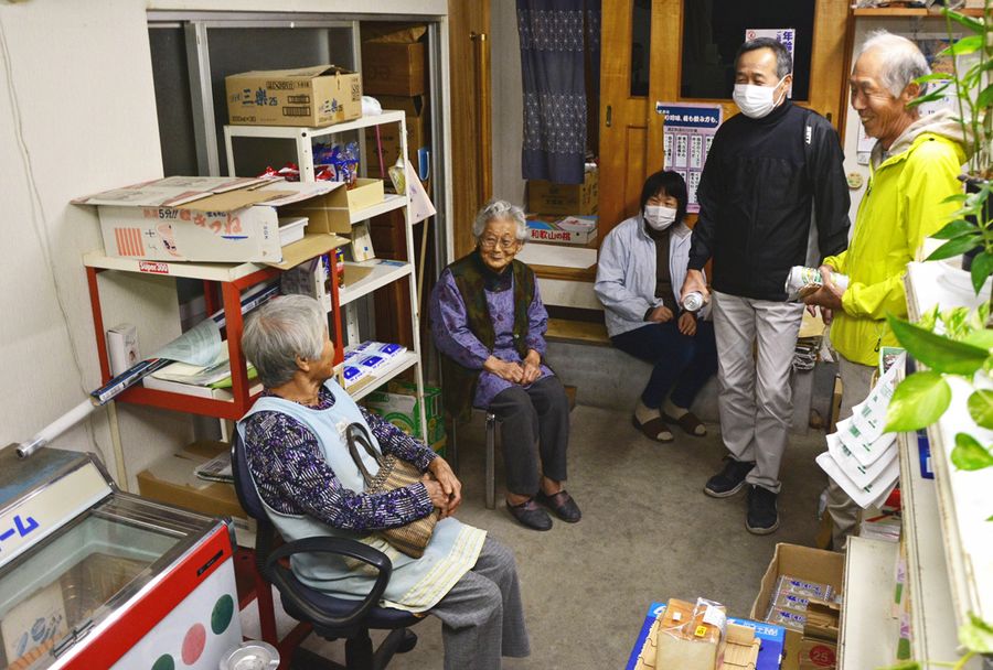 伊与野唯一の食料品店「岡松酒店」。夕方、店主の岡松浪子さん＝左から２人目＝を中心に人の輪ができた（写真はいずれも宿毛市小筑紫町伊与野）