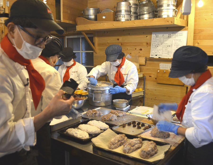 オンラインツアーの参加者に菓子工房の様子を中継する前成照さん＝左端（四万十町土居）