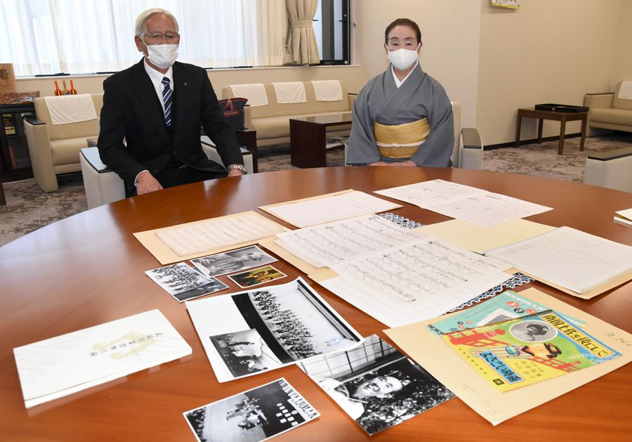 武政英策さんの楽譜や資料。親族の森田繁広さん（左）が高知市に寄贈した＝高知市役所