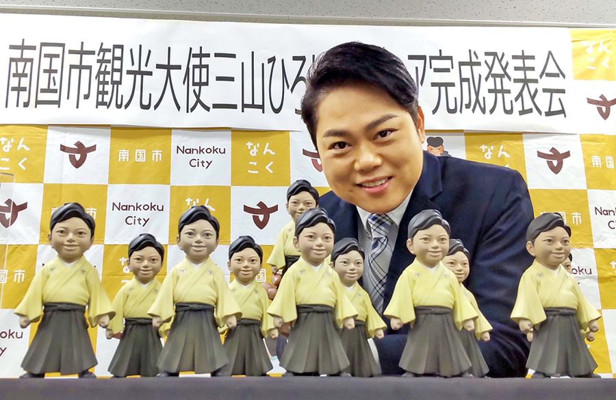 完成したフィギュアをPRする三山ひろしさん(南国市役所)