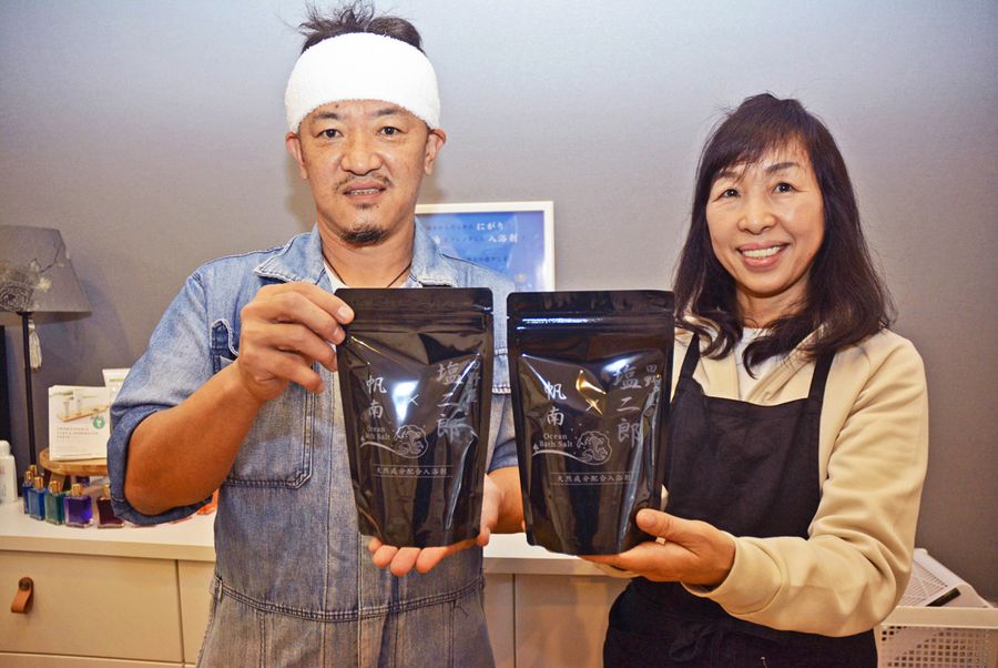 田野屋塩二郎さん=左=と浜渦千里さんのコラボで開発された「オーシャンバスソルト」(田野町)