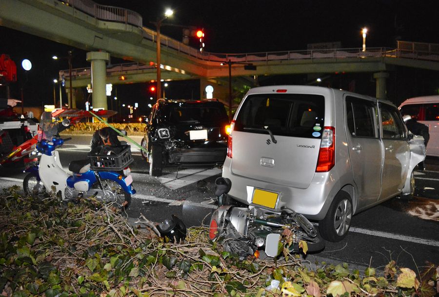 路肩を進んできた軽乗用車（右）はバイク２台に追突し、左の車に追突して停車した（２６日午後７時ごろ、高知市鴨部高町）