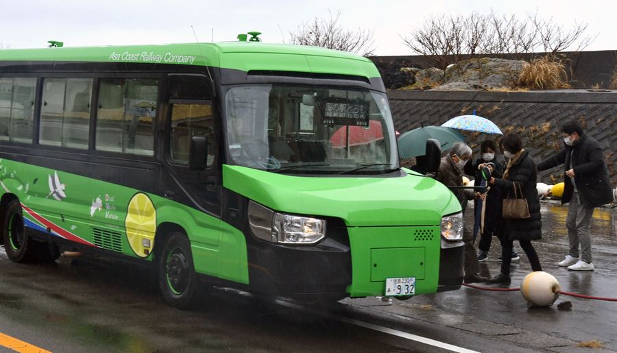 23日、むろと廃校水族館停留所で下車するDMVの乗客。運行開始から1カ月、室戸便は満席が続く(室戸市室戸岬町)