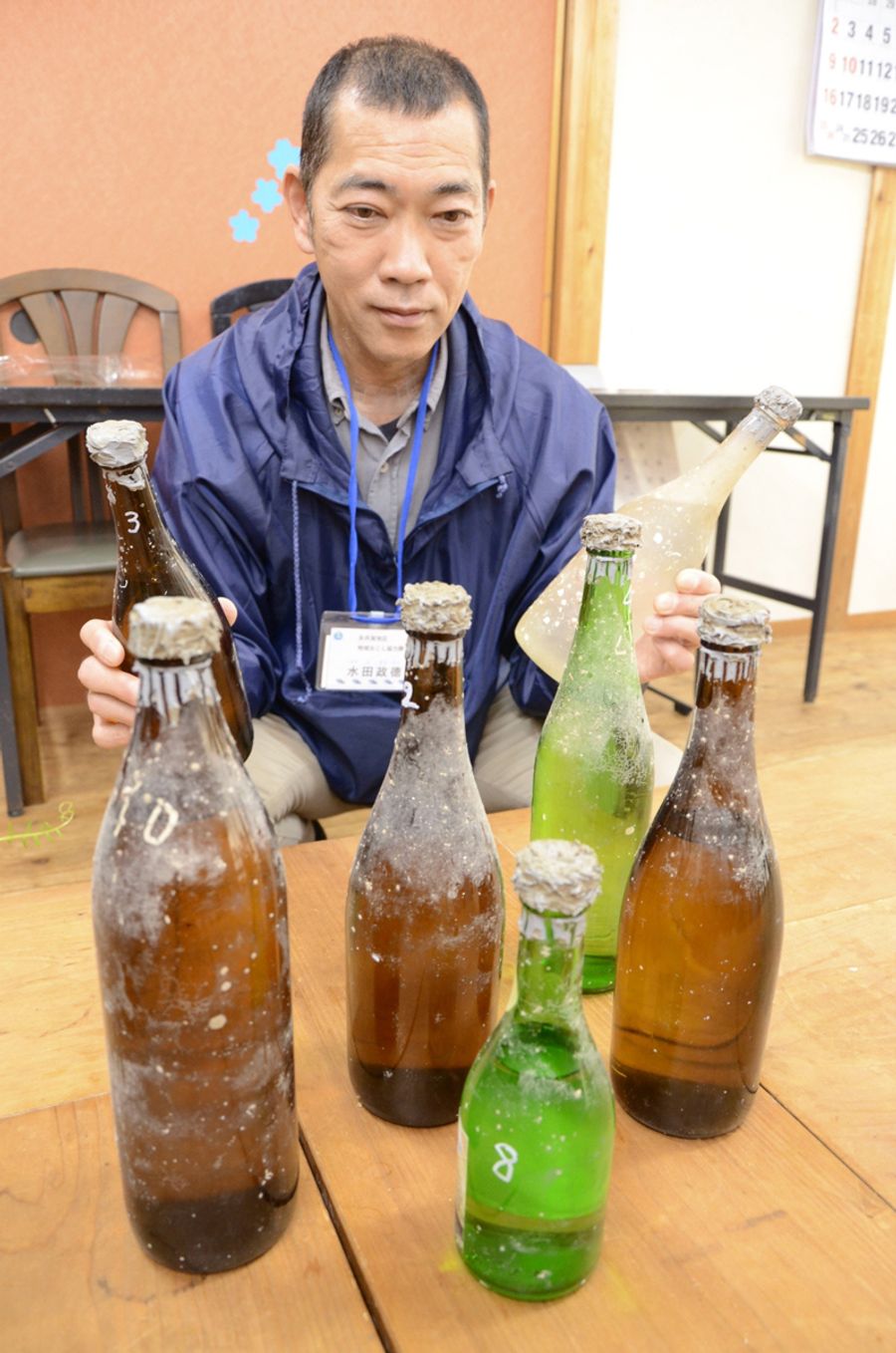 矢井賀沖に約5カ月間沈められていた酒と、企画した水田政徳さん(中土佐町の矢井賀高齢者コミュニティーセンター)