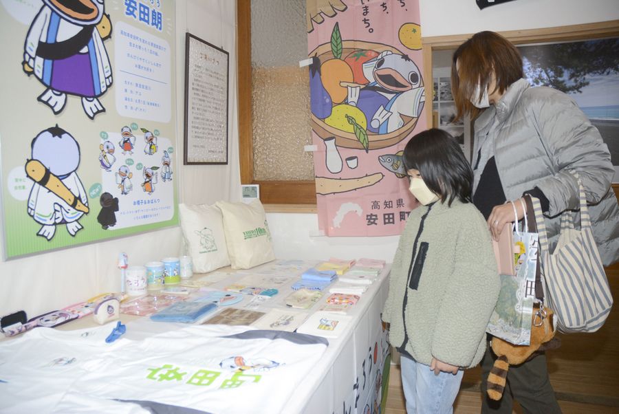 安田朗のグッズを興味深そうに見る親子連れ(安田町の安田まちなみ交流館「和」)