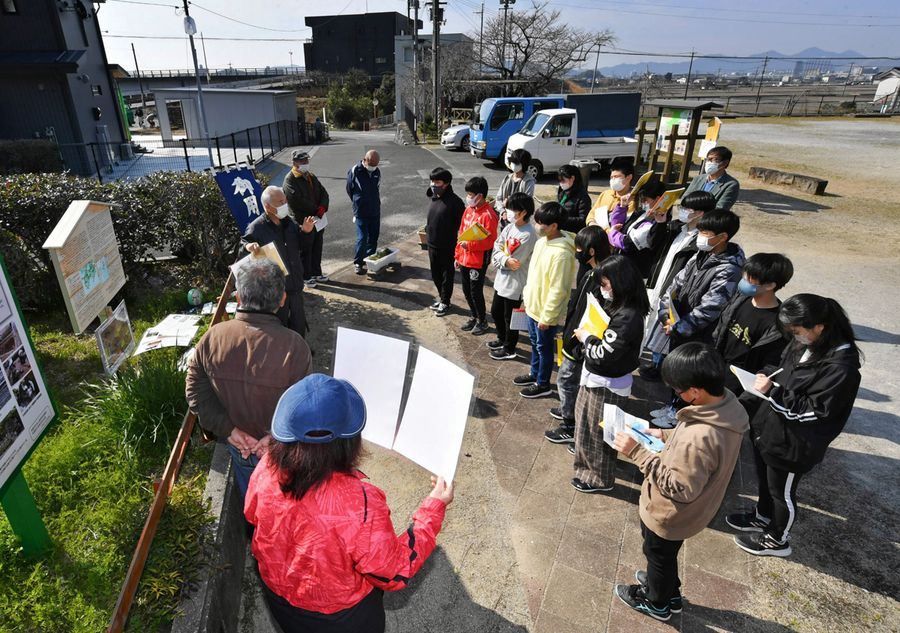 伊能測量の解説に耳を傾ける児童たち。昨年末には、歴史を解説する看板も新設された(高知市の布師田ふれあいセンター前=山下正晃撮影)