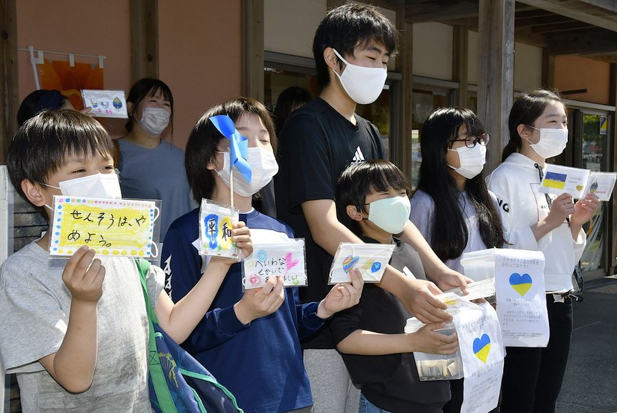 マスクを掲げてウクライナ支援の募金への協力を呼び掛ける子どもたち　（東洋町白浜の海の駅東洋町）