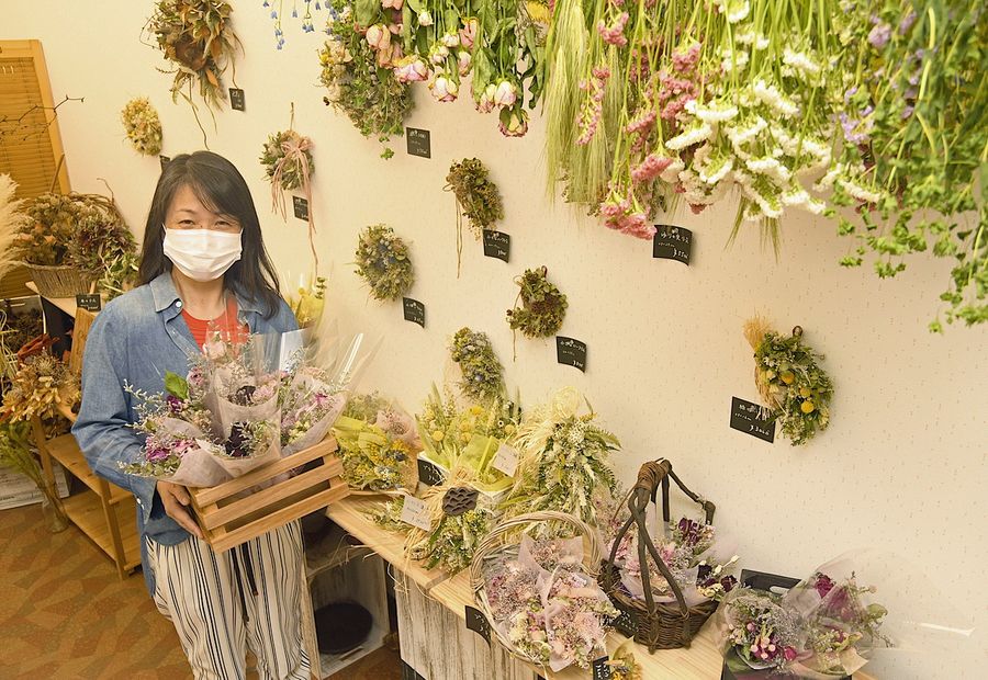 チャレンジショップでドライフラワー店を開いた有田直子さん。店内には鮮やかな花々が並ぶ(土佐清水市中央町)