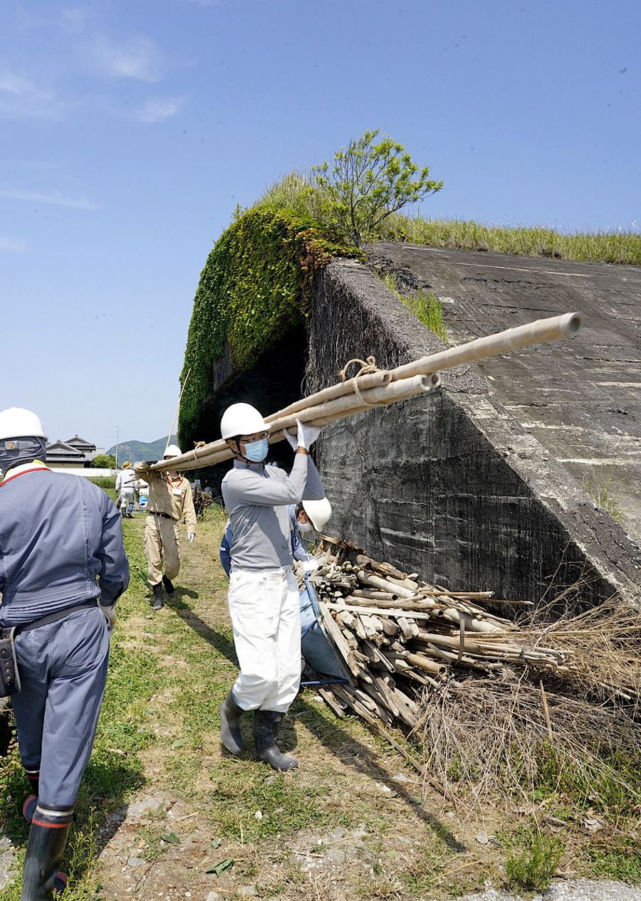 掩体清掃で木材などを運び出す参加者(南国市前浜)