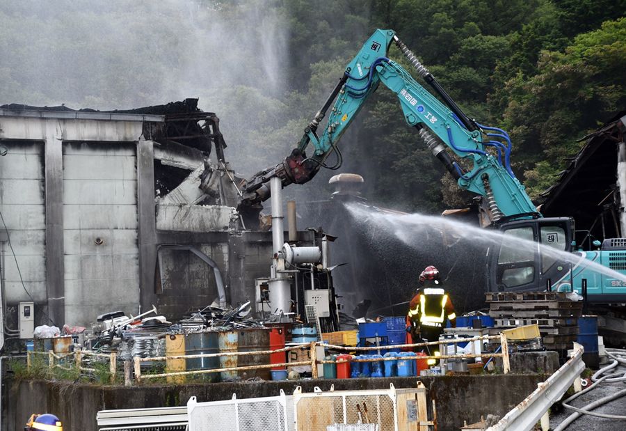 重機で倉庫を解体しながら放水が進められた火災現場(20日午後6時40分ごろ、高知市朝倉丙)