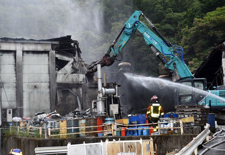 重機で倉庫を解体しながら放水が進められた火災現場（２０日午後６時４０分ごろ、高知市朝倉丙）