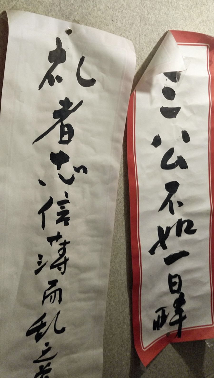 トイレの壁にマスターの毛筆。右は「1日の酔いは、高官に就くよりよっぽど大事」。左は「ぺこぺこするやつに限って忠心が薄く…」。漢詩の一節で、ざっとそんな意味らしい