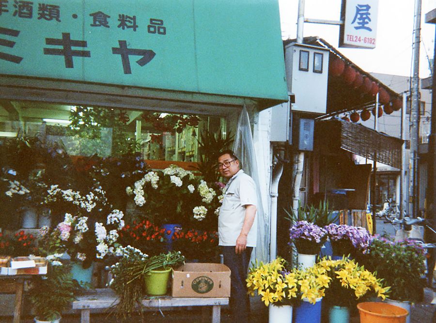 1991年当時、店先に立つ森尾圭介さん。軒先テントの色は緑だった(森尾夫妻提供)