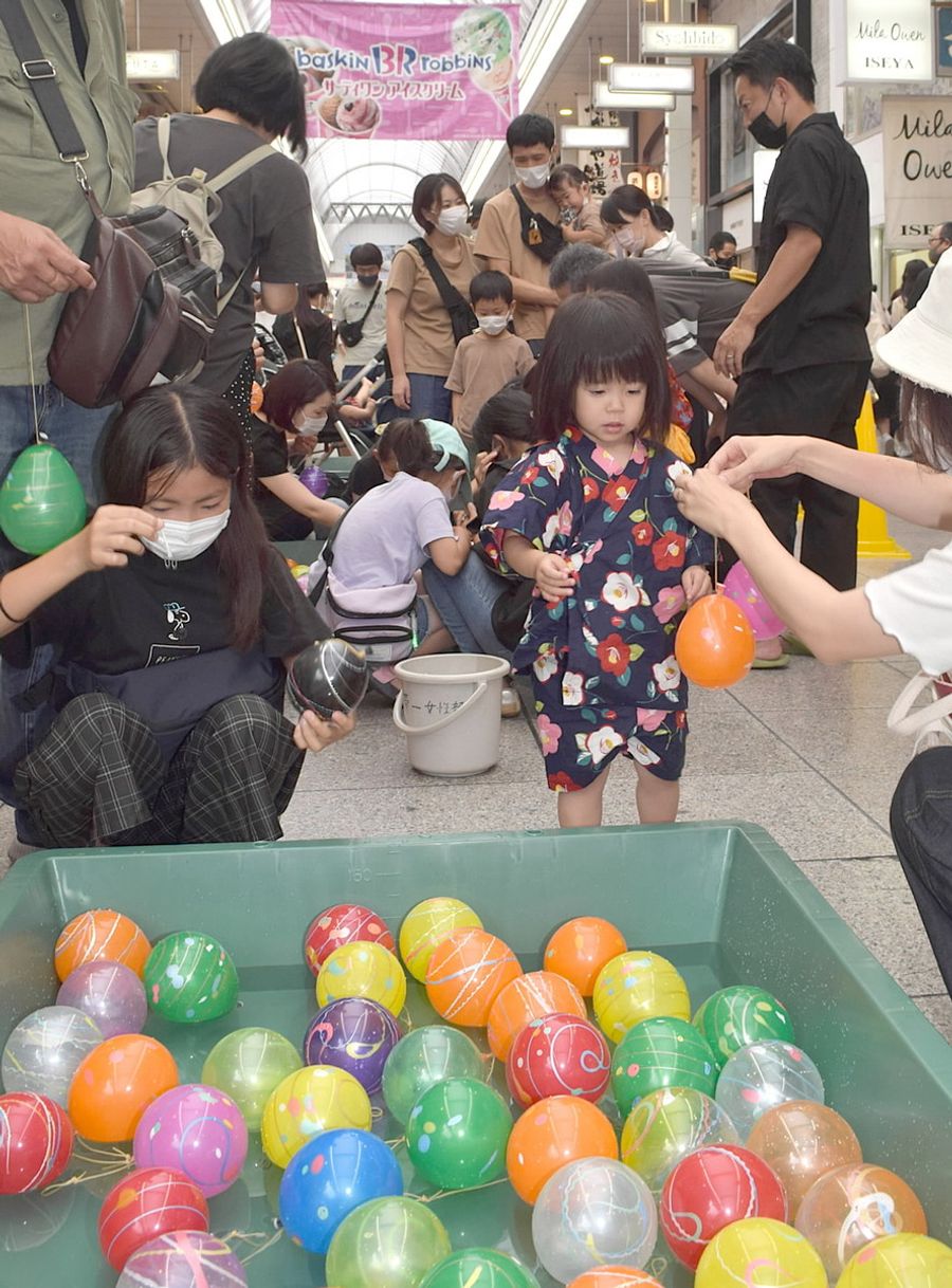 ヨーヨー釣りを楽しむ親子連れら（高知市帯屋町１丁目）