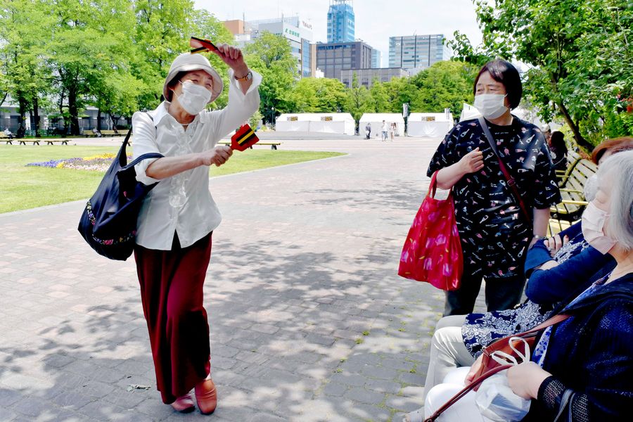 「飛び入り参加したくて鳴子持ってきたんだけど、今年はできないんだってね～」と話す女性