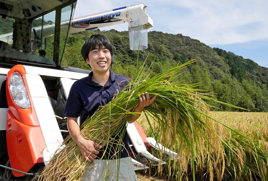 「おいしい米を作りたい」。最新型のコンバインで稲を刈る武内裕也さん（四万十町天ノ川）