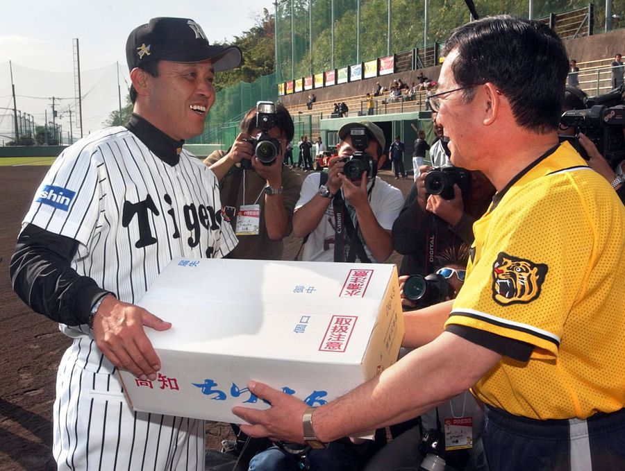 松本市長から特産品を受け取る岡田監督（安芸市の安芸球場）