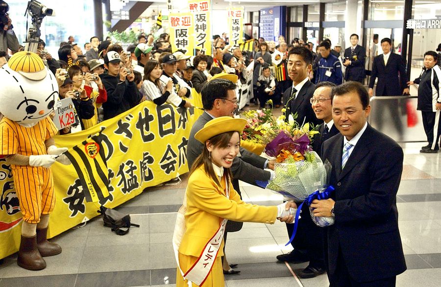 安芸市のキャンペーンレディらから花束を受け取る岡田監督（右）ら＝高知空港