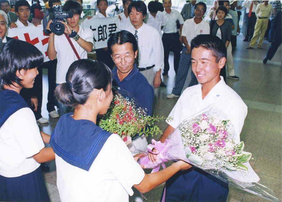 帰国して祝福の花束を受け取る弘井太郎（１９９８年７月１３日、高知空港）