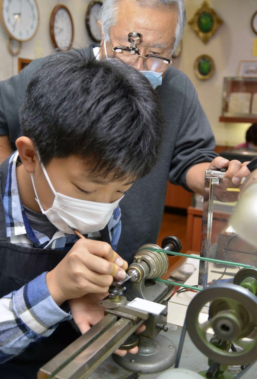 時計の部品を削り出す作業に挑む小幡昂輝君（写真はいずれも南国市の中村時計店）