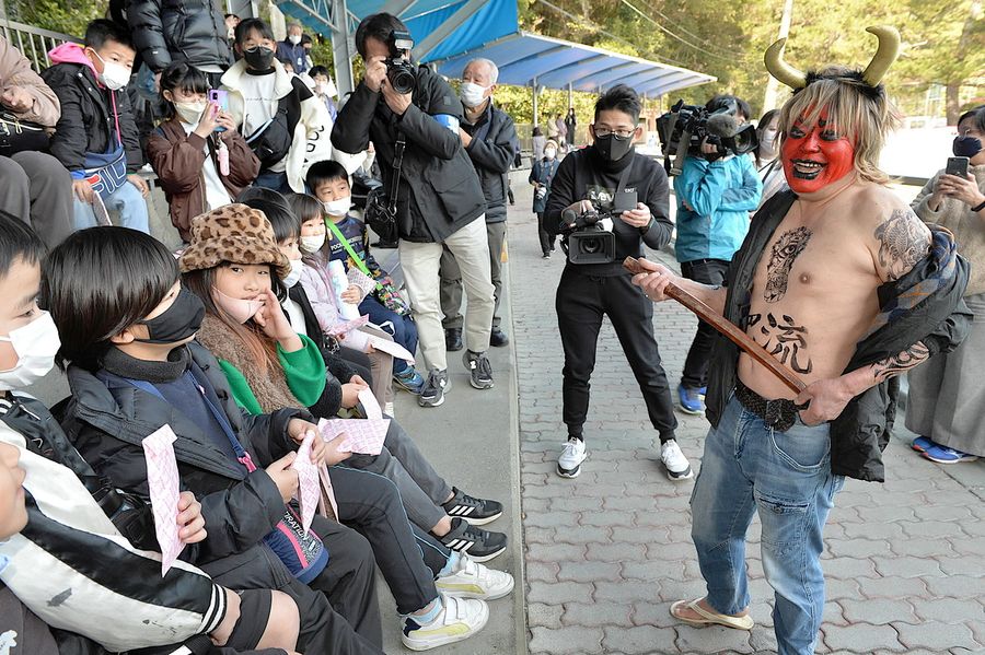 「怖すぎる」と評判の赤鬼と会話する児童ら（高知市の桂浜水族館）