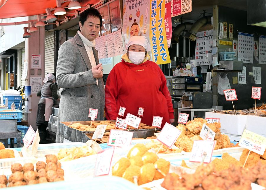 自宅に持って帰るためにげそ天やごぼう天を買い求める高知さん