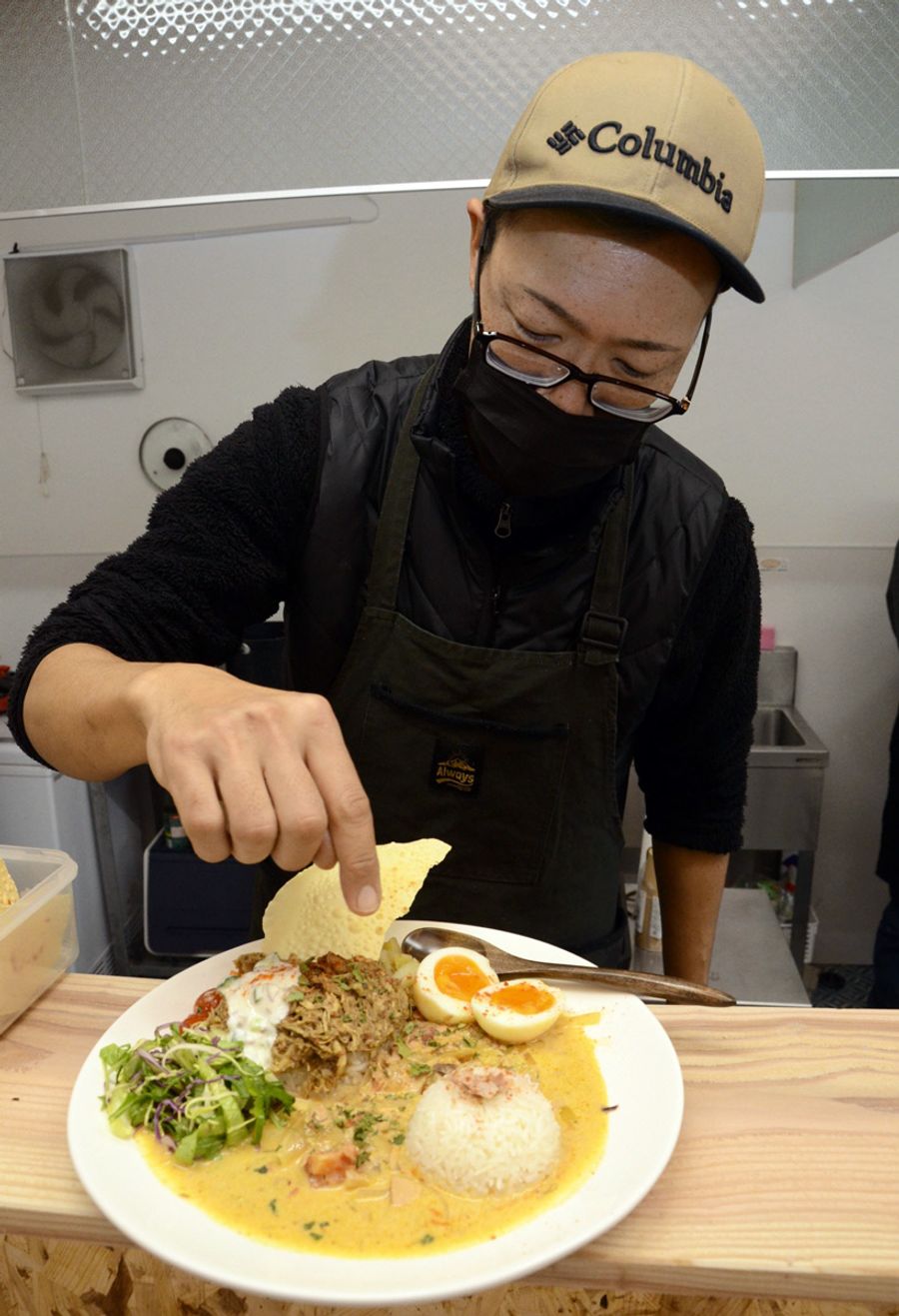 看板メニューの双名島カレーを説明する田中誠一さん（中土佐町のなかとさクレスタンカリー）