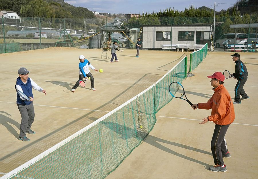 「ふんっ」。テニスファンが集まり、試合前のアップで体を温める（写真はいずれも高知市円行寺の高知ローンテニスクラブ）