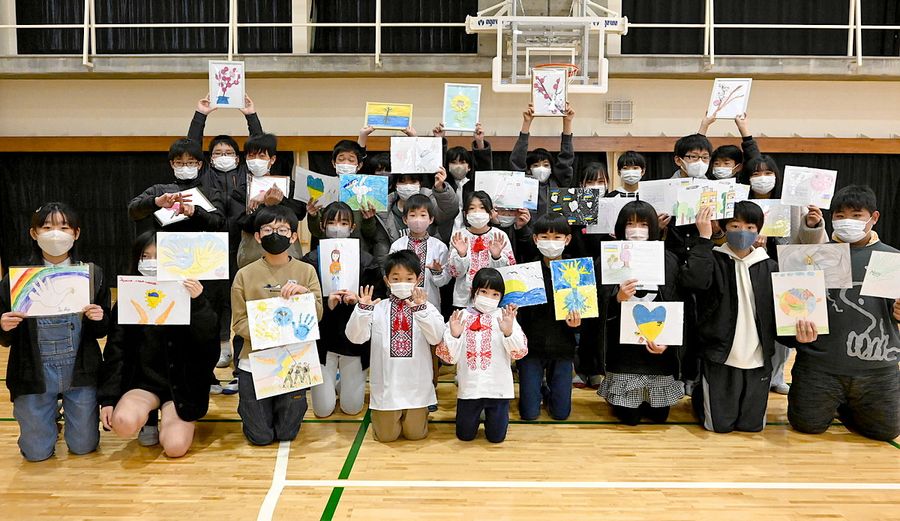 ウクライナから届いた絵手紙や民族衣装を受け取り喜ぶ三里小の児童ら(高知市仁井田)