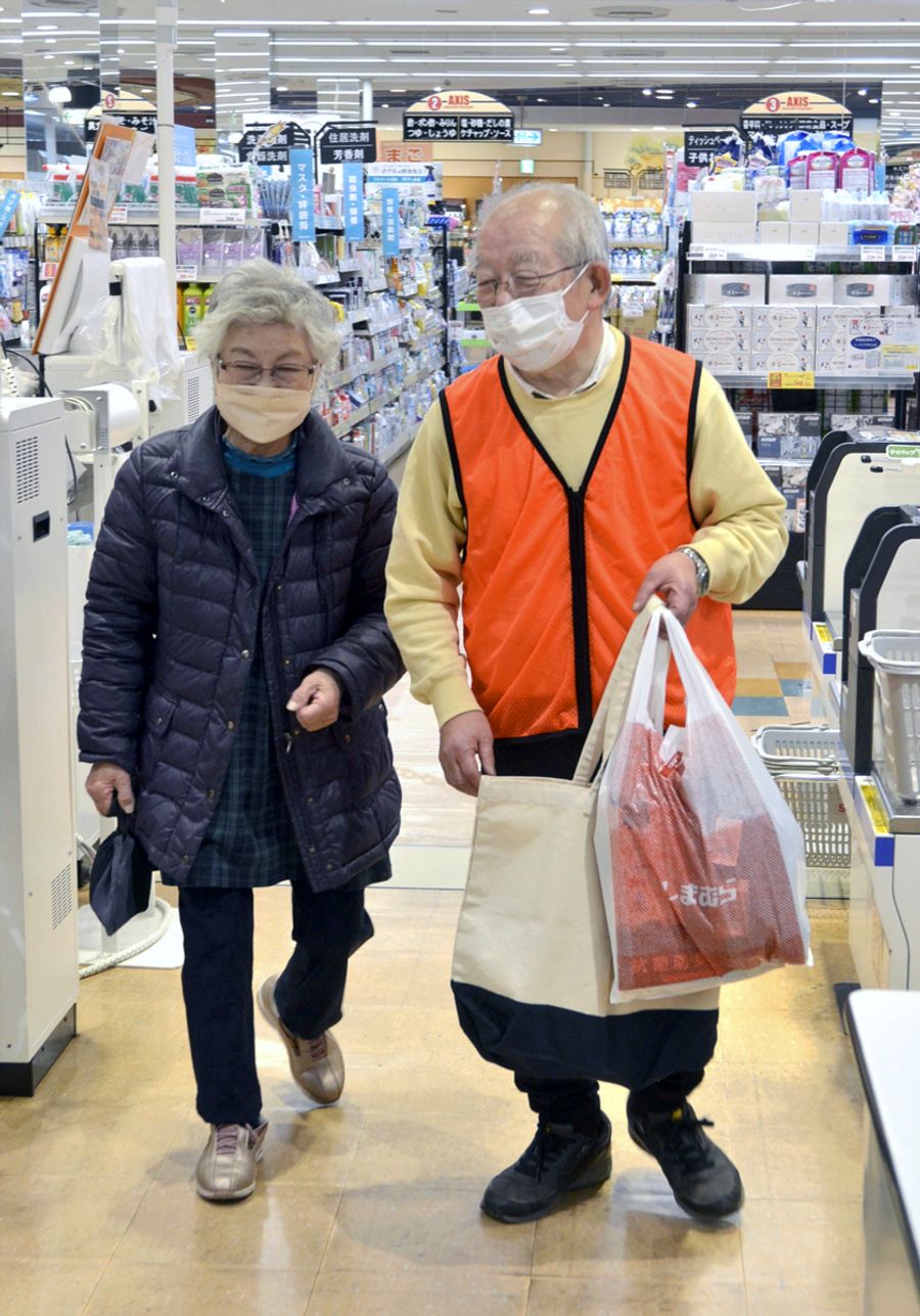 スーパーでのボランティアで、買い物客の荷物を運ぶ森田恒雄さん（右）＝南国市大埇乙のサニーアクシス南国店