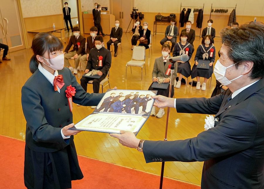 中平雅彦・高知新聞社社長から表彰状を受け取る香長中陸上部の北川あかりさん（高知市内のホテル＝反田浩昭撮影）