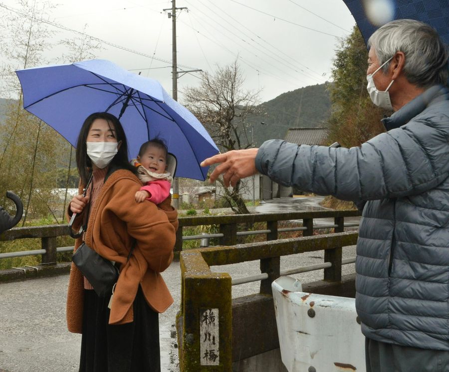 １歳の娘をおんぶして、住民の困り事を聞く杉山愛子さん（須崎市上分）