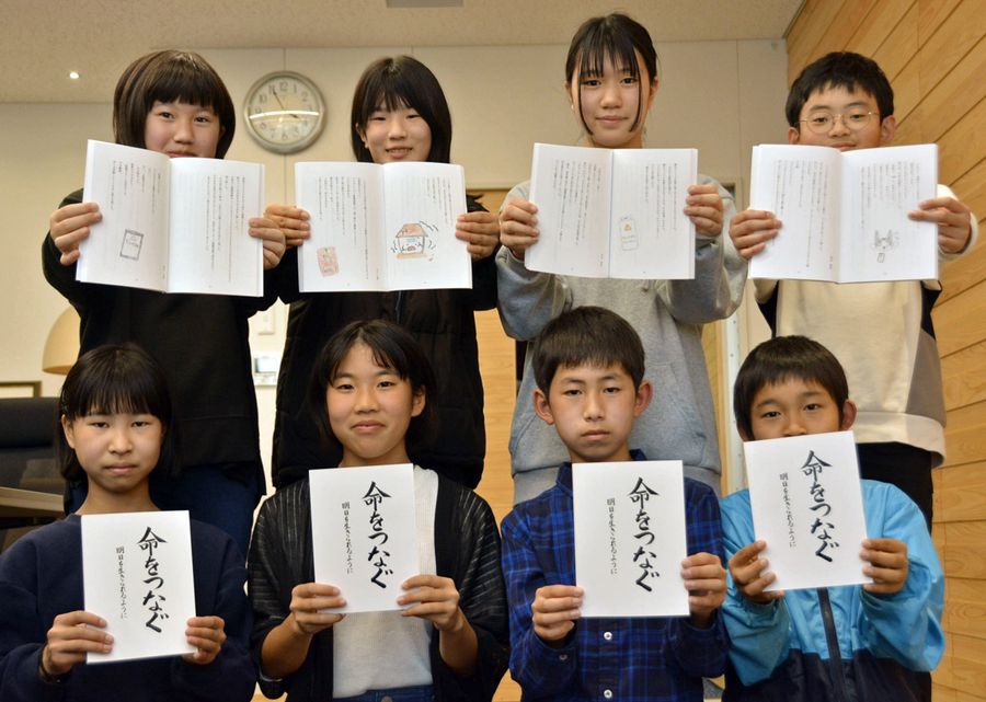 防災小説を手にする蓮池小学校の児童（土佐市役所）