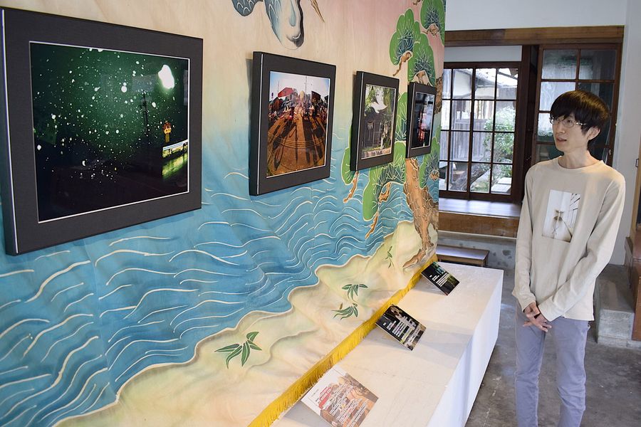 写真展を開いた横山佑樹さん。須崎の町並みを写した多彩な作品が並ぶ（須崎市青木町のすさきまちかどギャラリー）