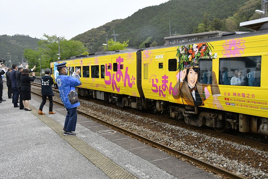 ラッピング列車を出迎え、乗客に手を振る住民ら（写真はいずれも佐川町甲のＪＲ佐川駅）