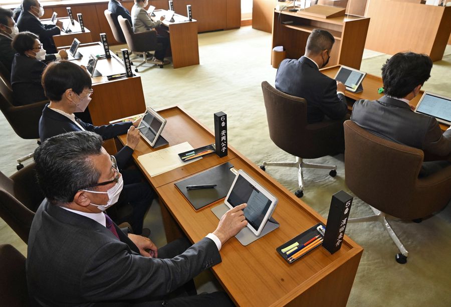 タブレットで議案書などをチェックする議員。紙の資料がない机の上はすっきり（芸西村役場）