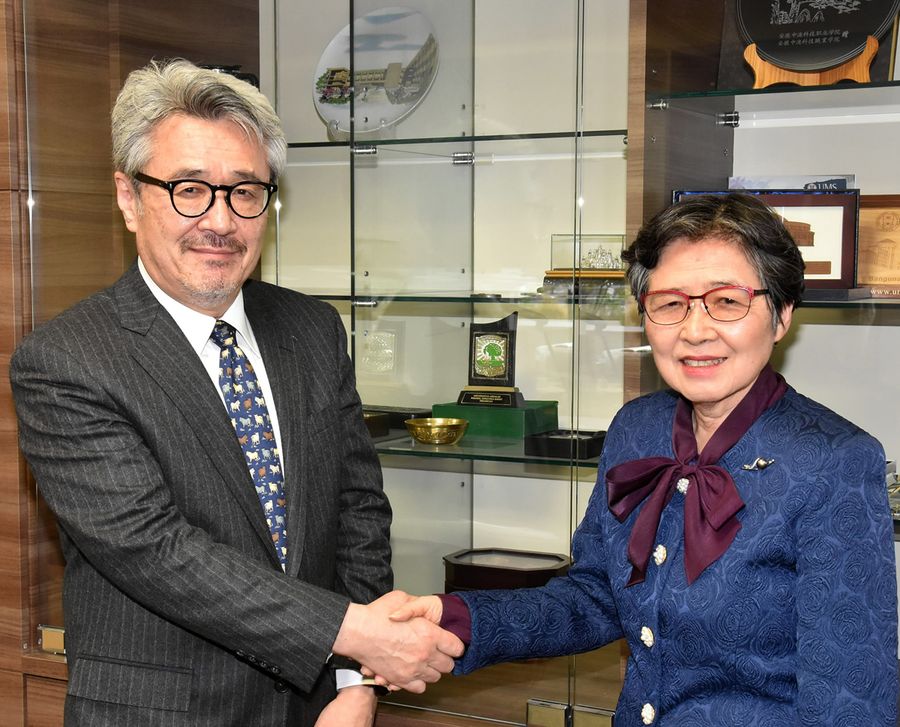 高知県立大の学長室で握手する甲田茂樹新学長＝左＝と野嶋佐由美前学長（高知市池）