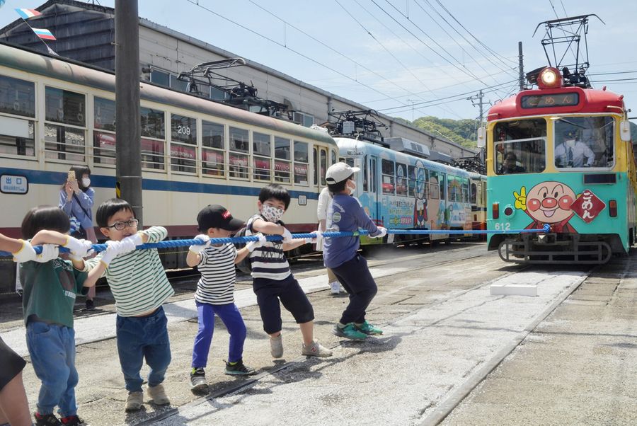 アンパンマン電車と綱引きする子どもたち（高知市桟橋通４丁目）