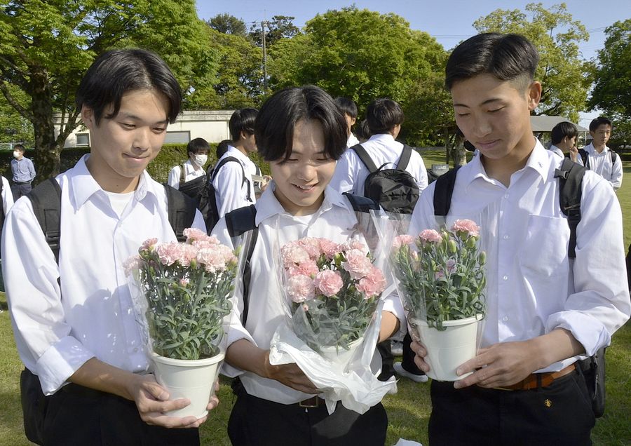 カーネーションを手に笑顔を見せる生徒（南国市の高知農業高校）