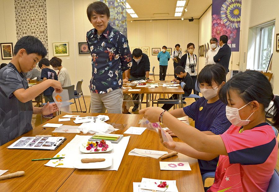 企画展に合わせたアート作品づくりで、子どもたちに手ほどきする杉野さん（中央）